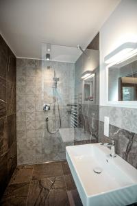 a bathroom with a sink and a shower at Tyrol Living & Cafe in Nova Levante