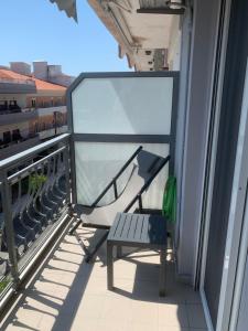 a bench sitting on the balcony of a building at Zeusplace NewWave Deluxe Apartment in Paralia Katerinis