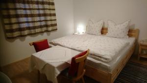 a bedroom with a bed and a table and chairs at Ferienwohnung Höllwarth in Gerlos