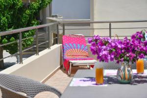 una mesa con un jarrón de flores púrpuras en el balcón en Katerina's house, en Kefálion