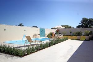 a backyard with a swimming pool with a chair at Recanto Villa REAL in Olímpia