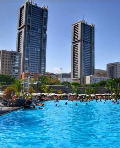 ein großes Schwimmbad in einer Stadt mit hohen Gebäuden in der Unterkunft Guest Room Santa Cruz in Santa Cruz de Tenerife