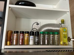 a shelf with a bunch of oils in a kitchen at Sfeervol huisje, dichtbij bos en centrum in Apeldoorn