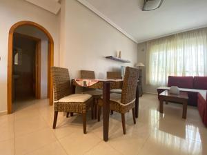 a living room with a table and chairs and a couch at Lomas de Cabo Roig in Orihuela Costa