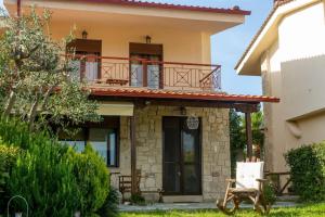 a house with a balcony on top of it at Villa Pino Pueblo in Paliouri