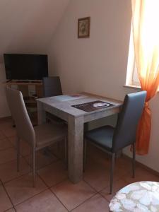 a dining room table with chairs and a television at Apartment OG 2 in Peine