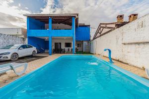 a swimming pool in front of a house with a car at Casa c piscina na Lagoa Manguaba Mal Deodoro AL in Marechal Deodoro