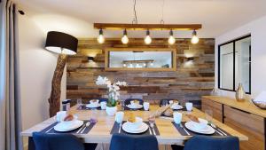 uma sala de jantar com uma mesa de madeira e cadeiras azuis em Élégant et Moderne avec Vue Montagne au Coeur de Paradiski - Garage - 8pers - 90m2 - Sabaudinha em Champagny-en-Vanoise