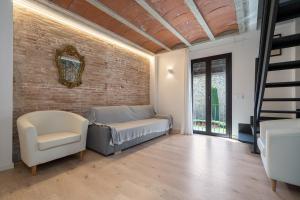a living room with a bed and a brick wall at Hauzify I Apartaments Montblanc in Montblanc