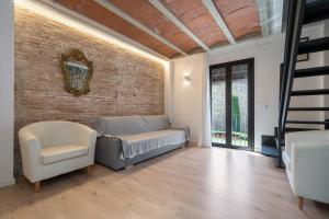 sala de estar con cama y pared de ladrillo en Hauzify I Apartaments Montblanc, en Montblanc