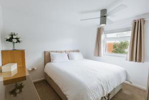 een witte slaapkamer met een bed en een raam bij SWINTON HOUSE - Beautiful 3 Bed House in Harrogate, North Yorkshire in Harrogate