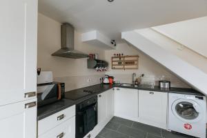 eine Küche mit weißen Schränken und einer Waschmaschine und einem Trockner in der Unterkunft ELM HOUSE COTTAGE - 2 Bed Cottage in High Hesket on the edge of the Lake District, Cumbria in High Hesket + 20 Fotos