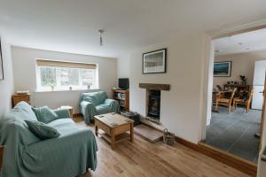 ein Wohnzimmer mit einem Sofa und einem Kamin in der Unterkunft ELM HOUSE COTTAGE - 2 Bed Cottage in High Hesket on the edge of the Lake District, Cumbria in High Hesket