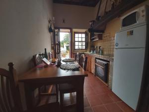 une cuisine avec une table en bois et un réfrigérateur blanc dans l'établissement Villa-Sleeps4-Parking-Garden-Pool-NearAirport, à La Laguna