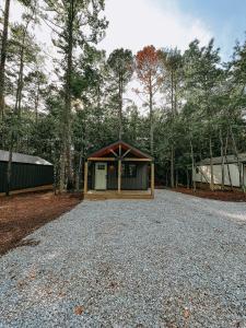 a small building on a gravel road in the woods at Cabin 2 One Bedroom W Kitchen in Hartwell