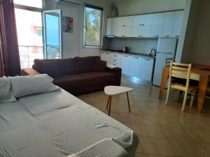 uma sala de estar com um sofá e uma cozinha em Antea Apartments 1-2 em Vlorë