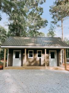 a small house with a metal roof and white doors at Cabin #3 One Bedroom W Kitchen in Hartwell