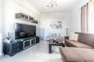 ein Wohnzimmer mit einem Sofa und einem großen TV in der Unterkunft Spacious House With SeaView in Iraklio