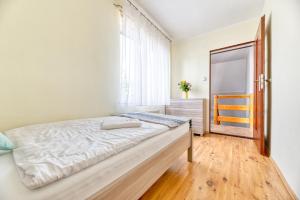 um quarto com uma cama e uma janela em Apartament Arturro z ogródkiem em Szklarska Poręba