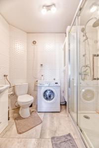 uma casa de banho com uma máquina de lavar roupa e um WC em Apartament Arturro z ogródkiem em Szklarska Poręba