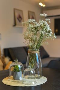 a glass vase with flowers in it on a table at Apartman Sinjska Alka in Sinj