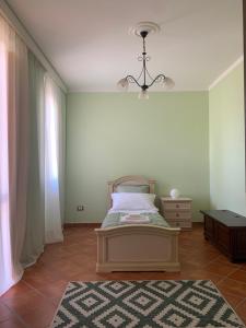 1 dormitorio con cama, ventana y alfombra en Relais Gregorio 2, en Paternopoli