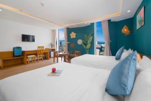 a hotel room with two beds and a dining room at Merry Land Hotel Da Nang in Danang