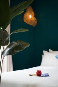 a red apple sitting on top of a bed at Merry Land Hotel Da Nang in Danang
