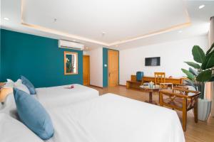 a bedroom with two beds and a blue wall at Merry Land Hotel Da Nang in Danang