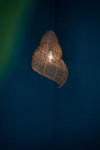 a wicker light fixture hanging from a wall at Merry Land Hotel Da Nang in Danang