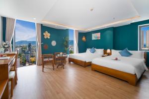 a hotel room with two beds and a table at Merry Land Hotel Da Nang in Da Nang