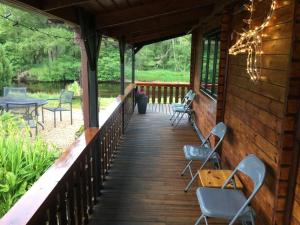 アビモアにあるRIVERSIDE LODGE RETREATの椅子とテーブル付きのキャビンのポーチ