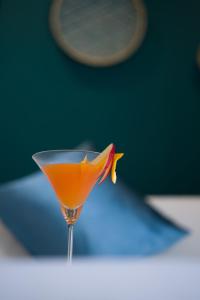 an orange drink in a martini glass on a table at Merry Land Hotel Da Nang in Danang