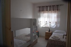 sypialnia z dwoma łóżkami piętrowymi i oknem w obiekcie Gli zii di Sicilia - casa vacanze w mieście Capri Leone