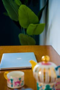 a laptop computer sitting on a wooden table with a tea pot at Merry Land Hotel Da Nang in Danang