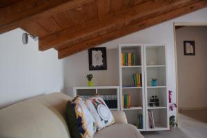 a living room with a couch and a book shelf at Gli zii di Sicilia - casa vacanze in Capri Leone