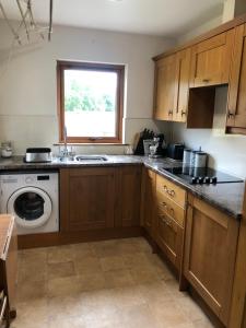 een keuken met een wastafel en een wasmachine bij River Ness View in Inverness