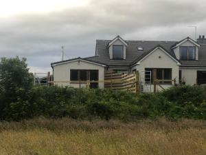 una casa blanca con techo de gambrel en River Ness View, en Inverness