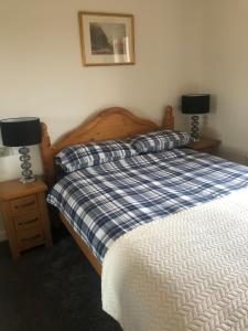 een slaapkamer met een bed met 2 lampen op nachtkastjes bij River Ness View in Inverness