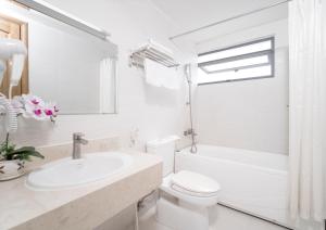 a white bathroom with a toilet and a sink at Merry Land Hotel Da Nang in Danang