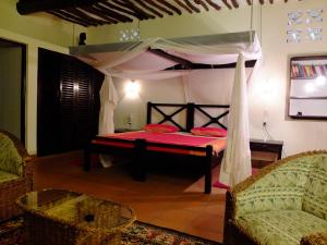 a bedroom with a bed with a canopy at Luxury Villa SOLEIL, Galu Diani Beach in Diani Beach