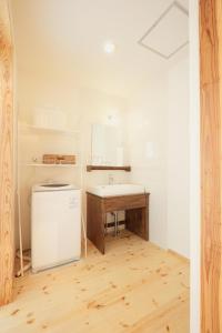 cocina con fregadero y nevera en una habitación en Cottage Kugino - Vacation STAY 84448v, en Minami Aso