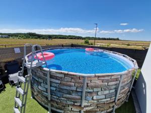 une grande piscine circulaire avec un frisbee dans l'établissement Domki Rajski Wypoczynek z basenem, à Jastrzębia Góra