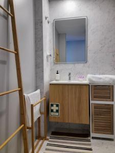 a bathroom with a sink and a mirror at White Design Apartment in Aveiro