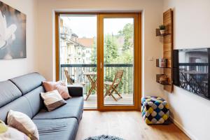 リュブリャナにあるWoody - comfy apartment in Šiškaのソファとガラスの引き戸のあるリビングルーム