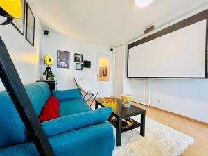 salon z niebieską kanapą i ekranem w obiekcie En mode cinéma! Hyper centre ville avec terrasse w mieście Chartres