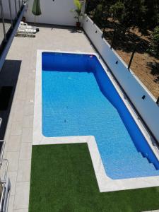 a swimming pool with blue water in a yard at VILLA CERRO E MAR Apartement in Moncarapacho