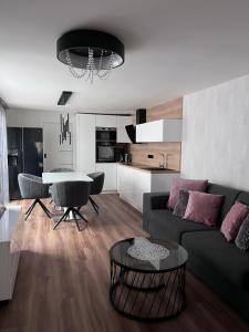 ein Wohnzimmer mit einem Sofa und einem Tisch in der Unterkunft Elizabeth´s apartments in Velké Pavlovice