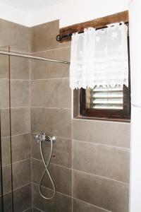 a bathroom with a shower with a window at Una Guest House in Bosanski Novi