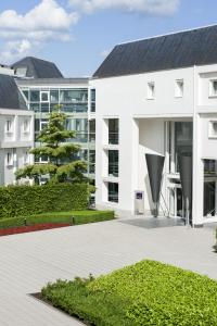an external view of a white building with a courtyard at Novotel Brugge Centrum in Bruges